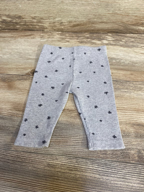Front view of grey ribbed baby leggings (3-6 months) showcasing ribbed texture and small dark star print on wood background