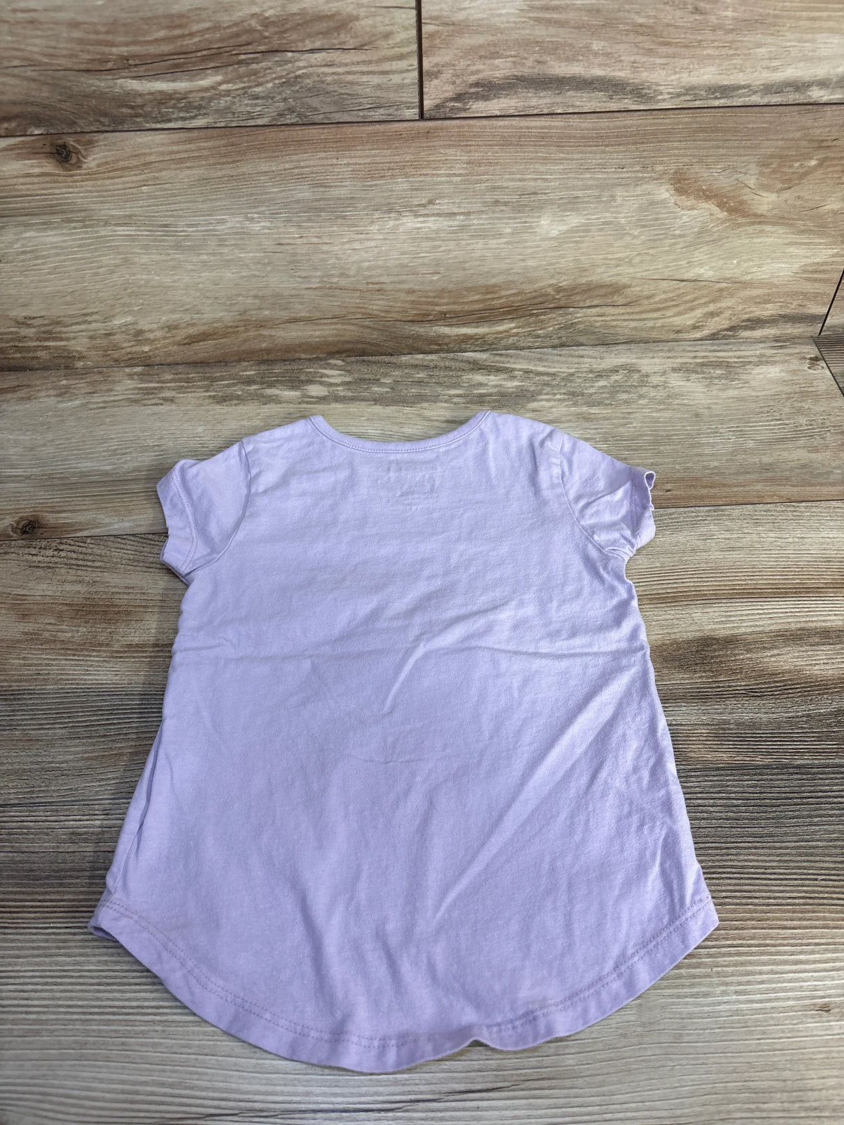 Back view of girls Nickelodeon Santiago of the Seas lilac t-shirt showing short sleeves and curved hem on wooden floor
