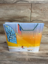 Back cover of Wei Skates On hardcover book showing illustrated indoor ice rink with American flag, warm sunset lighting, and small skating figure on a wood surface