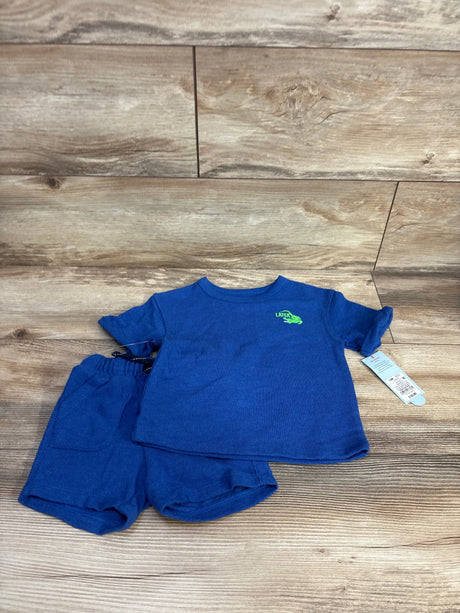 Top view of Cat & Jack blue 2pc terry shirt and shorts showing green Later gator graphic and elastic waist on wood floor