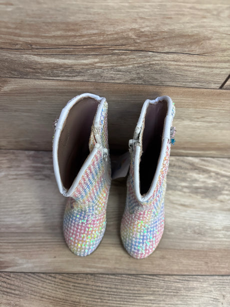 Pair of colorful children's sparkly boots with side zippers on wooden floor background