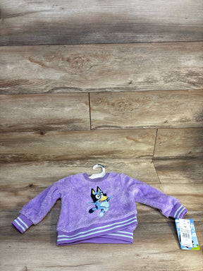 Purple fuzzy toddler sweatshirt with Bluey cartoon character on wood background