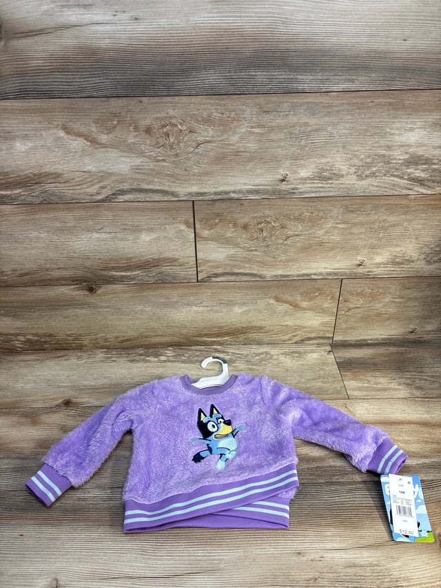 Purple fuzzy toddler sweatshirt with Bluey cartoon character on wood background