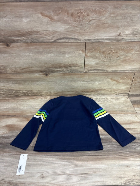 Back view of Janie and Jack Apres Ski long sleeve shirt in navy, showcasing striped sleeves on a wood background