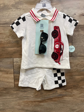 Top-down view of Little Lad white 3-piece polo shirt, shorts, and sunglasses set with racing car and checkered accents