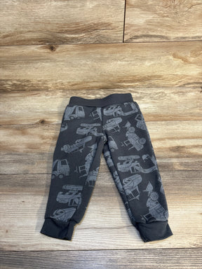 Gray toddler pants with construction vehicle print, displayed on wood floor