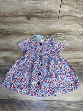 Flat lay of Ophelia toddler dress, size 2T, showing center wooden buttons and small multicolor floral print on wood floor