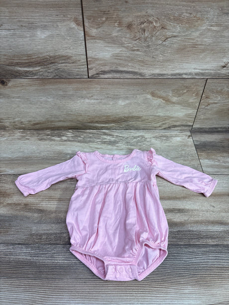 Front view of pink Barbie long sleeve bubble romper showcasing ruffled shoulders and snap closure on wood background