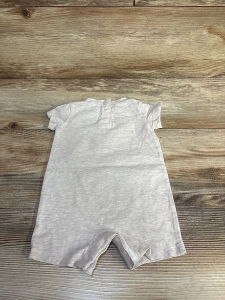 Flat-lay back view of beige Nike shortie romper size 3M showing short sleeves and short leg openings on wood background