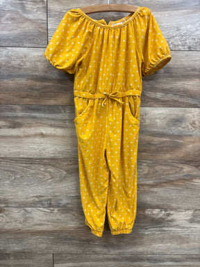 Front view of Old Navy yellow jumpsuit with puff sleeves, drawstring waist, pockets and elastic ankles on wood background