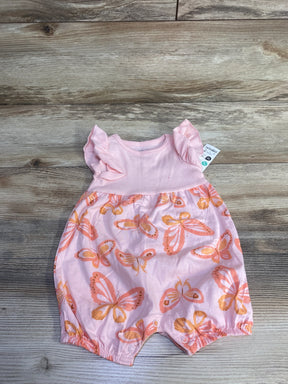 Flat-lay of Just One You butterfly sleeveless shortie romper size 6M showing ruffle shoulder sleeves, snap leg closures, and orange butterfly print on wood background