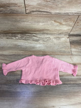 Pink baby girl long-sleeve sweater with ruffled cuffs and hem on wooden floor