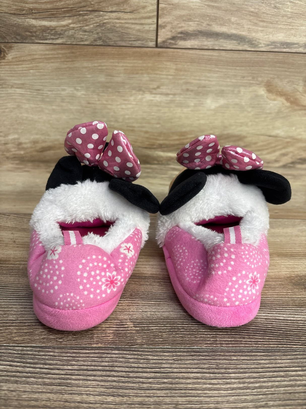 Pair of pink toddler slippers with white polka dot bows and black ears, soft fuzzy lining