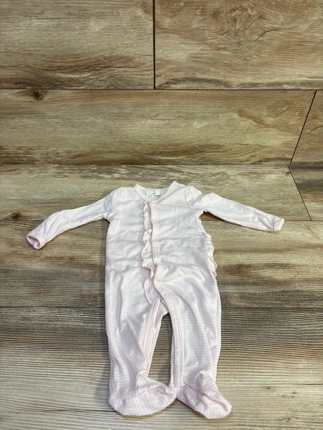Flat lay of newborn pink snap-front sleeper showcasing ruffle trim, built-in feet, and front snaps on wood floor