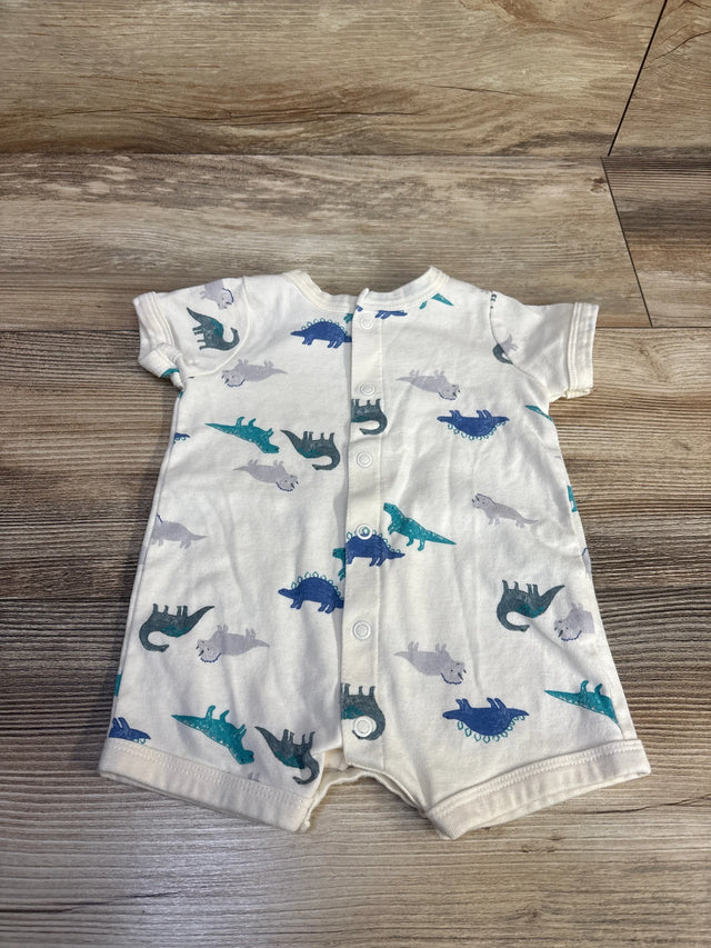 Flat-lay of Carter's white shortie romper showcasing front snap closure and blue and teal dinosaur print on wood background