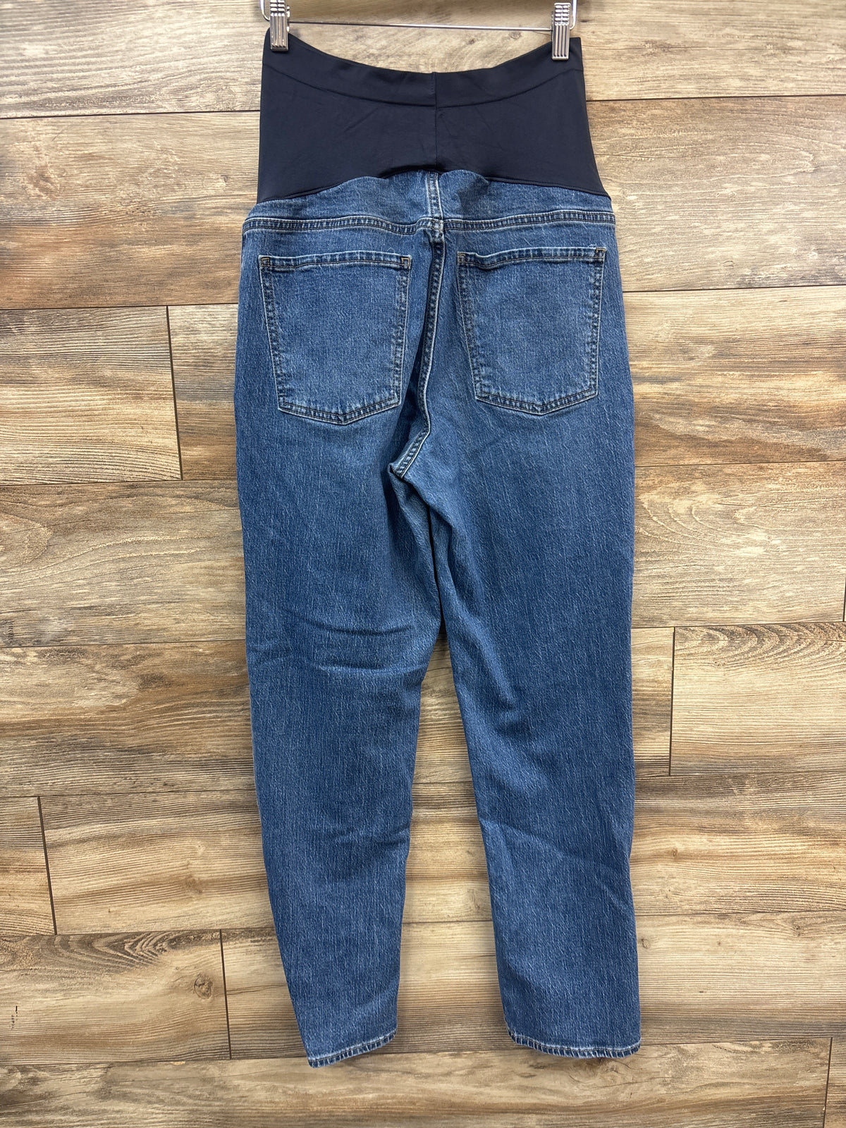 Back view of Old Navy maternity boyfriend jeans showcasing blue denim, full panel, and back pockets on a wood floor