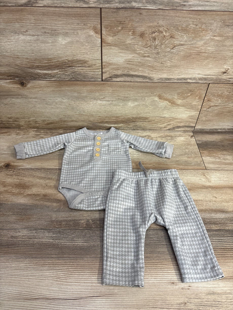 Gray houndstooth patterned baby bodysuit with wooden buttons and matching pants on wooden floor