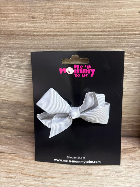 Front view of a grey solid hair bow showcasing its ribbed texture on a black display card