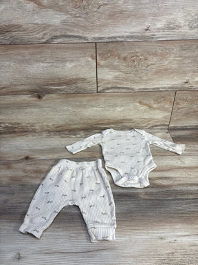Flat-lay of ivory ribbed baby bodysuit and matching pants with ribbed texture and gray animal print on wood background