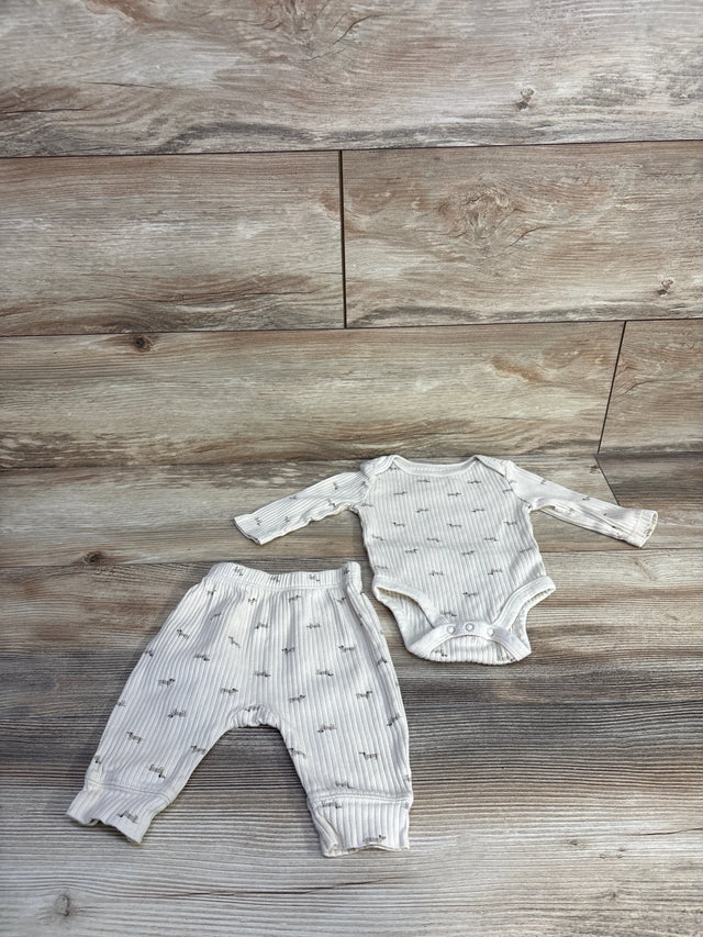 Flat-lay of ivory ribbed baby bodysuit and matching pants with ribbed texture and gray animal print on wood background