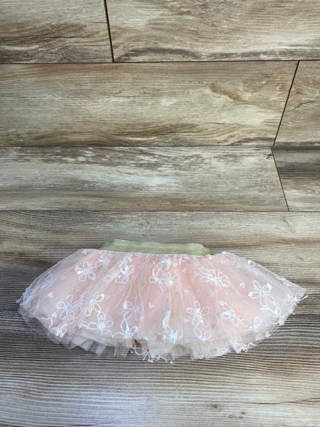 Flat lay of pink embroidered tulle baby skirt size 0-12 months showcasing gold elastic waistband on wood background