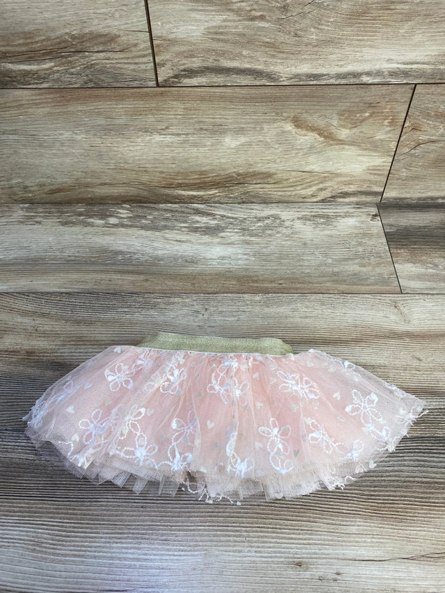 Flat lay of pink embroidered tulle baby skirt size 0-12 months showcasing gold elastic waistband on wood background