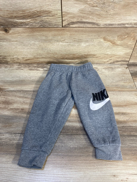 Gray Nike toddler sweatpants with logo on wooden floor
