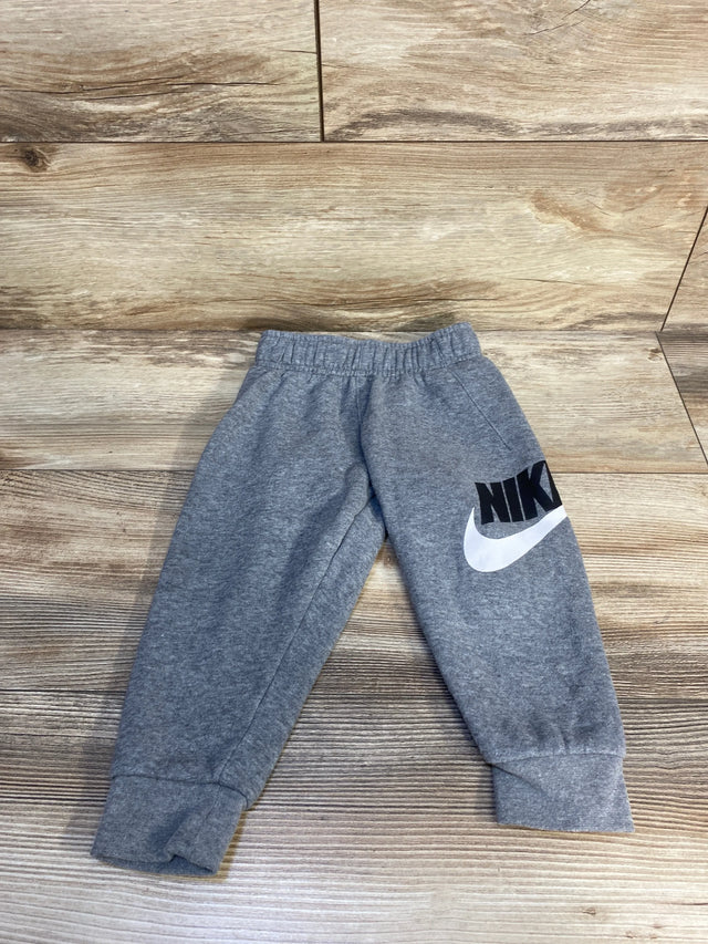 Gray Nike toddler sweatpants with logo on wooden floor