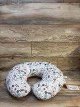 Floral nursing pillow for babies with black, red, and blue pattern on wood floor