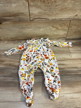 Overhead view of white Laughing Llama snap sleeper in size 9 months, with floral print and footed legs on wood floor