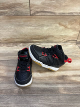 Front three quarter view of black AND1 high-top basketball shoes with red trim, velcro strap and gum sole on wood floor