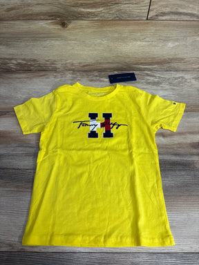Bright yellow Tommy Hilfiger kids crewneck t-shirt with navy and red logo on wooden surface
