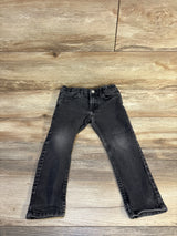 Black denim kids jeans laid flat on wood background, children's clothing resale