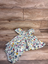 Flat lay of green floral tiered toddler dress with matching bloomers in organic cotton poplin on wood background