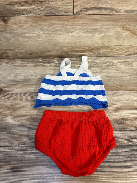Flat lay of Cat and Jack 2-piece 4th of July set with blue-white tank, white straps, and red bloomers on wood background