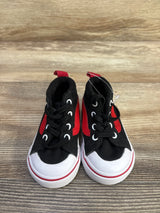 Front view of Vans Racer Mid sneakers showing black canvas with red side stripe and white rubber toe caps on wood background