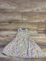 Flat-lay of girls Penelope Mack yellow floral button-front dress showcasing sleeveless ruffled collar and full skirt on wooden floor background