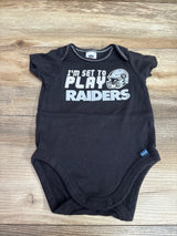 Front view of black Raiders bodysuit, size 0/3m, with I’m Set To Play graphic and snap closures on wood background