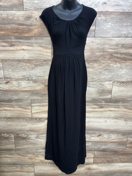 Front view of black maternity cap-sleeve maxi dress with empire waist and gathered skirt on mannequin against wood backdrop