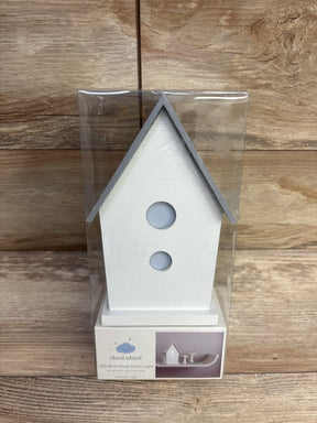 White LED birdhouse night light in packaging, wooden background, nursery decor