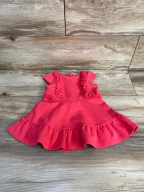 Flat lay of pink Janie and Jack baby ruffle dress showing ruffled bodice, cap sleeves, and ruffled hem on wood floor
