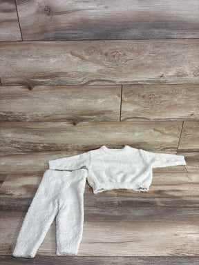 White fuzzy long-sleeve crop top and matching high-waisted pants children’s outfit laid flat on wood floor