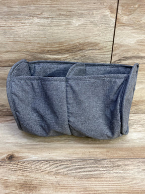 Front view of grey fabric playard organizer showing three pockets and padded sides on wooden backdrop