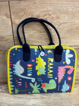 Front view of Hooku Montessori Busy Felt Book showing navy felt cover with colorful dinosaur prints, yellow trim, twin handles and button-loop closure on wooden floor