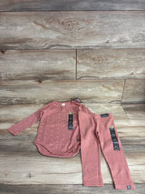 Flat lay of red ribbed 2-piece infant set long sleeve bodysuit with dot texture and wooden button, ribbed pants on light wood