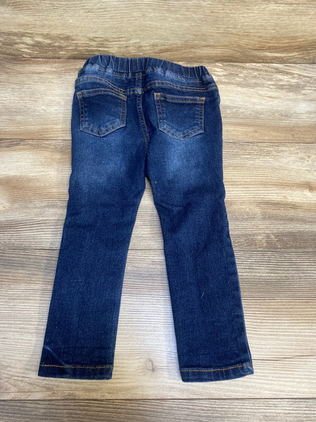 Dark wash kids jeans with elastic waistband and back pockets on wood background