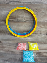 Colorful kids bean bag toss game with rings and patterned bags on wood floor