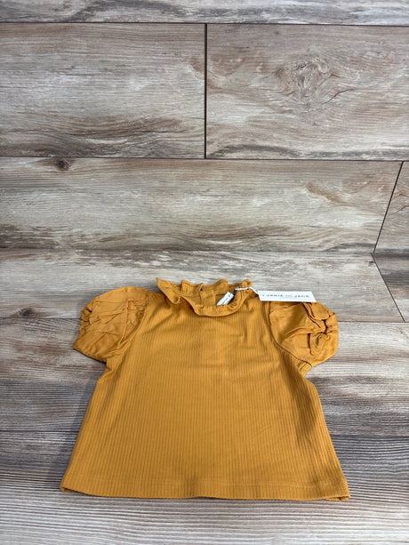 Mustard yellow ribbed toddler shirt with ruffled neck and puff sleeves on wooden floor