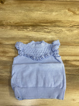 Flat lay of Janie & Jack Skyline crochet sleeveless top showcasing ruffled yoke and ribbed hem on wooden background