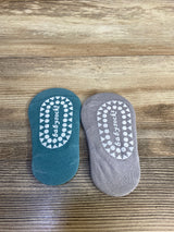 Top-down view of two-pack of non-slip baby socks grey and blue showcasing white patterned non-slip grips on wooden background
